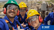 Three production employees with safety equipment look friendly into the camera. Three production employees with safety equipment look friendly into the camera.